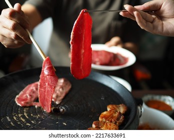 Cooking Grilled Beef In Korean BBQ Non-Stick Grill Pan With Chopsticks. Enjoy Eating Korean Dish Moment. People Stay Home And Enjoy Cooking Lifestyle. (close Up, Selective Focus)