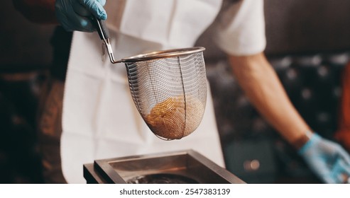 Cooking, hands and steaming noodles in strainer for traditional cuisine, culinary culture and meal preparation. Person, gloves or boiling ramen for nutrition, healthy dinner or lunch in Japanese cafe