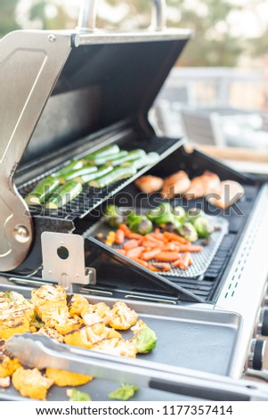 Cooking healthy dinner on outdoor gas grill.