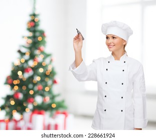 Cooking, Holidays, Advertisement And People Concept - Smiling Female Chef, Cook Or Baker With Marker Writing Something On Virtual Screen Over Living Room And Christmas Tree Background