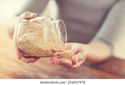 Cooking And Home Concept - Close Up Of Female Emptying Jar With Quinoa