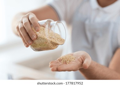 Cooking And Home Concept - Close Up Of Male Emptying Jar With Quinoa