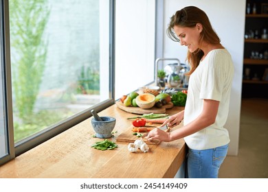 Cooking, home and happy woman with healthy food, meal prep and cutting fresh vegetables for lunch. Diet, wellness and girl at kitchen counter with ingredients, nutrition and dinner in apartment. - Powered by Shutterstock