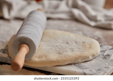 Cooking homemade bread. Sieving flour over raw bread dough rolled with rolling pin on marble board, dark background, selective focus. Baker hands on dough. - Powered by Shutterstock