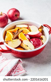 Cooking Homemade Hot Cider From Apples And Oranges With Spices In A Red Saucepan. Autumn Or Winter Warming Drink.