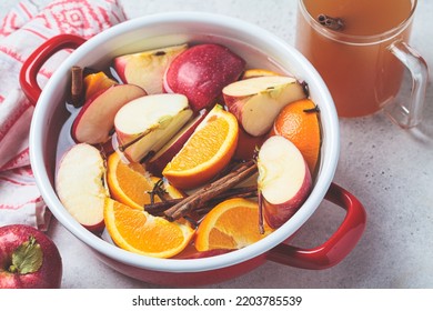 Cooking Homemade Hot Cider From Apples And Oranges With Spices In A Red Saucepan. Autumn Or Winter Warming Drink.