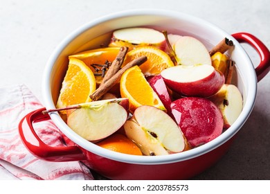 Cooking Homemade Hot Cider From Apples And Oranges With Spices In A Red Saucepan. Autumn Or Winter Warming Drink.