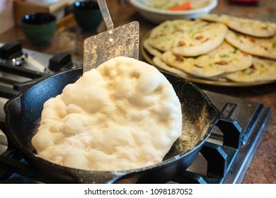 Cooking Homemade Naan Bread On The Stove Top In An Iron Skillet