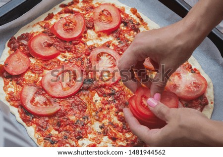 cooking homemade pizza with tomatoes