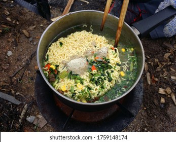 Cooking Instant Nodles At Outdoors In Black Pot At Picnic On Fire.