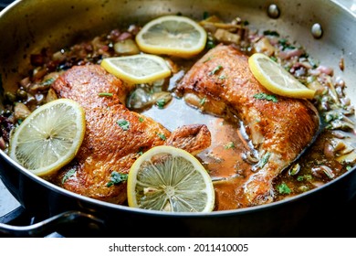 Cooking Italian Split Chicken Leg Piccata In Large Pan On Kitchen Stove