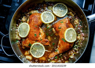 Cooking Italian Split Chicken Leg Piccata In Large Pan On Kitchen Stove