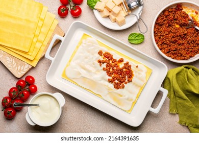 Cooking Lasagna.  Raw Italian Pasta In Casserole And Ingredients, Lasagne Flat Sheets, Meat Sauce Or RagÃ¹ Bolognese, Ground Meats And Tomato Sauce, Parmesan Cheese, BÃ©chamel Sauce. Directly Above.