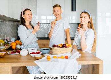 Cooking Lesson. Happy Mom Teaching Adult Daughter And Teen Son Prepare Healthy Nutrition, Caucasian Mother With Two Grown Children Talking Smiling Engaged In Useful Activity At Kitchen.