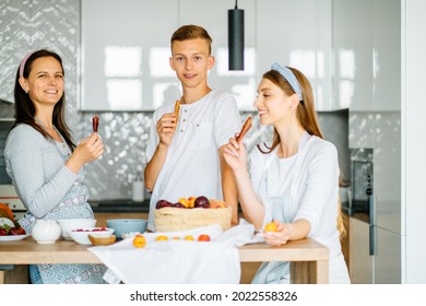 Cooking Lesson. Happy Mom Teaching Adult Daughter And Teen Son Prepare Healthy Nutrition, Caucasian Mother With Two Grown Children Talking Smiling Engaged In Useful Activity At Kitchen.