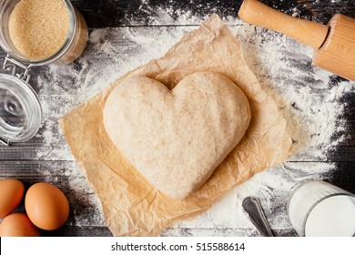 Cooking With Love. Dough In Heart Shape Top View. Baking Ingredients On The Dark Wooden Table