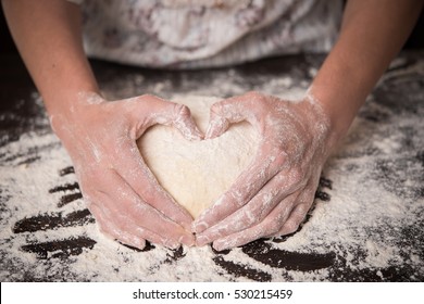 Cooking With Love. Female Hands Holding Dough In Heart Shape