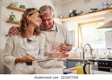 Cooking, love and food with a senior couple baking in the kitchen of their retirement home together. Romance, affection and bake with an elderly man and woman pensioner preparing a meal in the house - Powered by Shutterstock