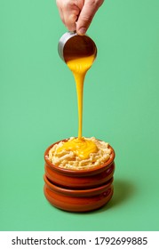 Cooking Mac And Cheese With Melted Cheddar Cheese Dripping Over Boiled Macaroni, Isolated On A Green Background. Pouring Cheese On Pasta. Hot Food.