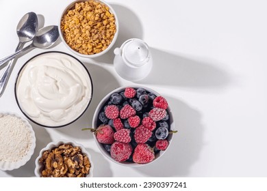 Cooking making Frozen Yogurt Bark background with greek yogurt, fresh berry, granola, honey, chocolate sauce, with baking tray deco. Top view of woman hands cook frozen yoghurt bars - Powered by Shutterstock