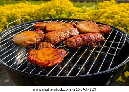 Cooking meat on a small charcoal round grill
