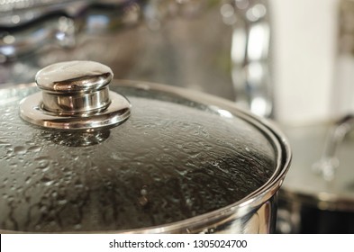 Cooking  Metal Pot With Lid Covered With Condensate Water Drops Is On The Stove. Kitchen Background Close Up. Boiling Water Concept. 