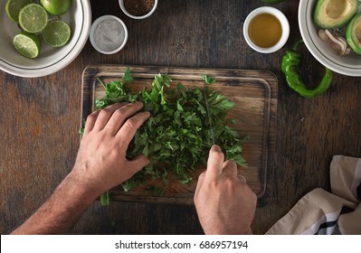 Cooking of Mexican guacamole sauce. Man preparing Mexican sauce guacamole, top view - Powered by Shutterstock