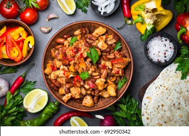 Cooking Mexican taco with meat beans and vegetables at black slate table. Latin american food background. Top view. - Shutterstock ID 692950342