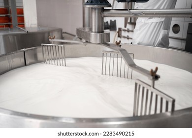 Cooking milk in a stainless steel tank for cheese production. Cheese factory concept. Copy space - Shutterstock ID 2283490215