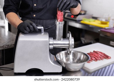 Cooking minced pork and beef by passing it through a electric meat grinder in the restaurant kitchen - Powered by Shutterstock