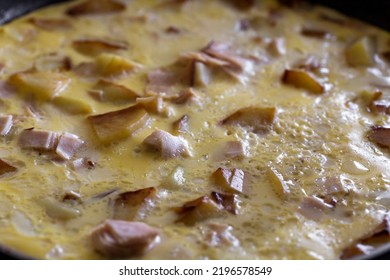 Cooking Omelette Made With Eggs, Potatoes And Ham In Pan