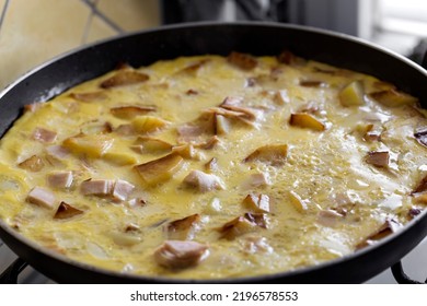 Cooking Omelette Made With Eggs, Potatoes And Ham In Pan