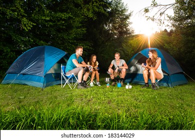 Cooking On A Camping With A Group Of Young Friends