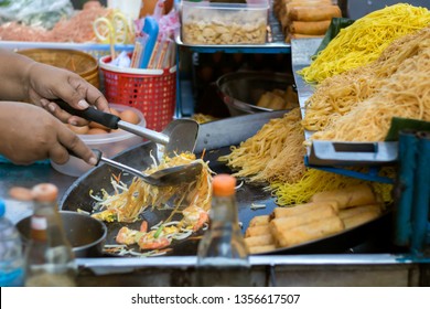 Cooking pad thai fried noodles at a street hawker mobile restaurant in Bangkok, Thailand. - Powered by Shutterstock