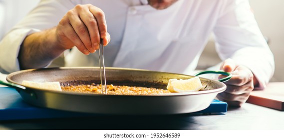 Cooking Paella Chef Checks Readiness With Tweezers - Spanish Food