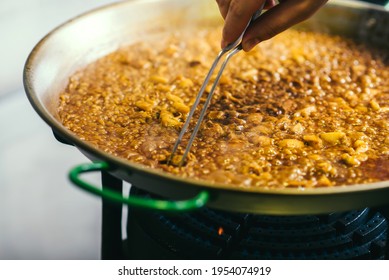 Cooking Paella Chef Checks Readiness With Tweezers - Spanish Food