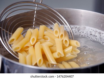 Cooking Pasta - Penne - in boiling Water - Shutterstock ID 1476204407