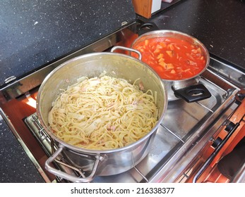 Cooking Pasta With Sausage And Meat Gravy On Stove In Yacht Galley