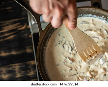 Cooking Pasta Spaghetti With Creamy Sauce With Mushrooms On Iron Pan Background.