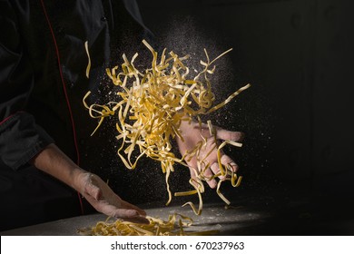 Cooking pasta spaghetti dough with flour on dark black background with space area. Food banner, big size resolution.