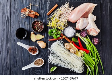 Cooking Pho Ga - Raw Ingredients For Asian Chicken Soup With Rice Noodles, Bean Sprouts, Onion, Herbs And Spices On A Black Slate Tray On A Table, View From Above,  Flatlay