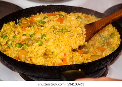 Cooking pilaf at home: rice is over the meat and vegetables 