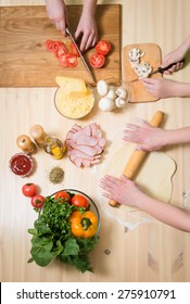 Cooking Pizza At Home. Filling Pizza With Ingredients. Top View Of Hands And Table With Ingredients. Overhead View.