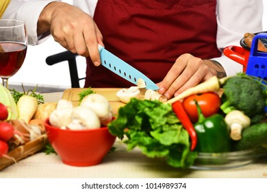 Cooking process concept. Male hands cut mushroom with knife, apron on background. Cook burgundy uniform cuts vegetables. Chef prepares meal. - Powered by Shutterstock