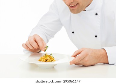 Cooking, Profession, Haute Cuisine, Food And People Concept - Close Up Of Happy Male Chef Cook Decorating Dish