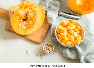 cooking pumpkin soup. pieces of pumpkin in bowl and pumpkin seeds
