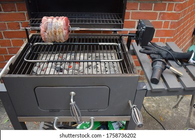 Cooking Rotisserie Beef Roast Skewered Lengthwise Juicy Meat Slowly Roasted Over A Low Fire Charcoal Grill In London Garden When Carved Into Paper-thin Slices The Juices Run Out Onto The Cutting Board