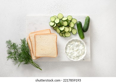 Cooking Sandwiches With Cucumber And Dill For English Tea Traditional Breakfast On White Background. View From Above. Crispy Freshness Cold Appetizer.