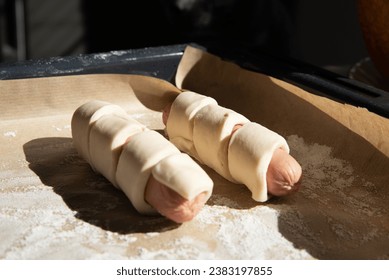 Cooking sausages in dough, home baking, the process of cooking according to the recipe before baking.