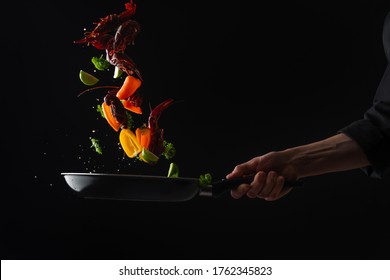 Cooking Seafood, Frying In A Pan With Vegetables, Veggie Healthy Food, On A Black Background, Menu And Restaurant Business